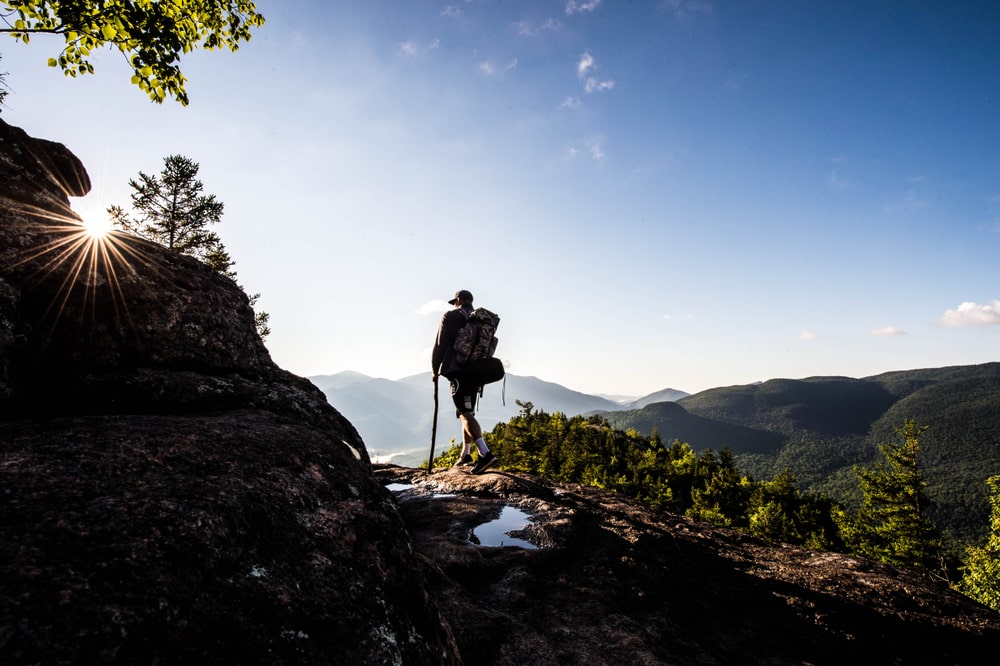Man hiking to the top of the best hikes in Lake George