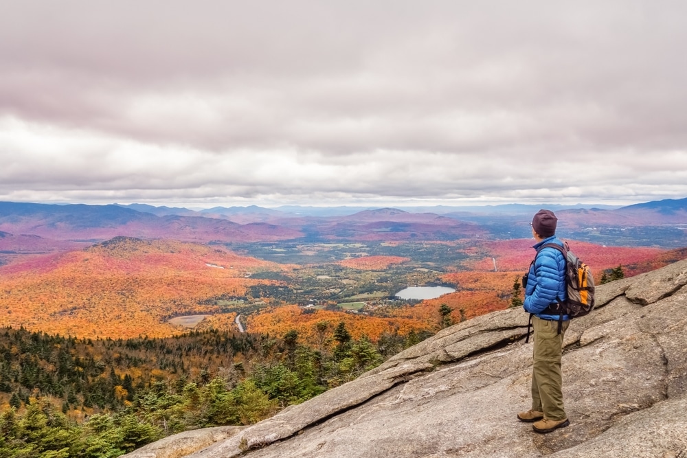 Man taking in the view from one of the best hikes in the Adirondacks
