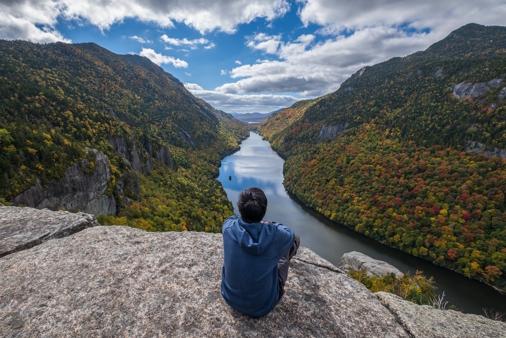 Man enjoying the view from Indian Head, one of the best hikes in the Adirondacks